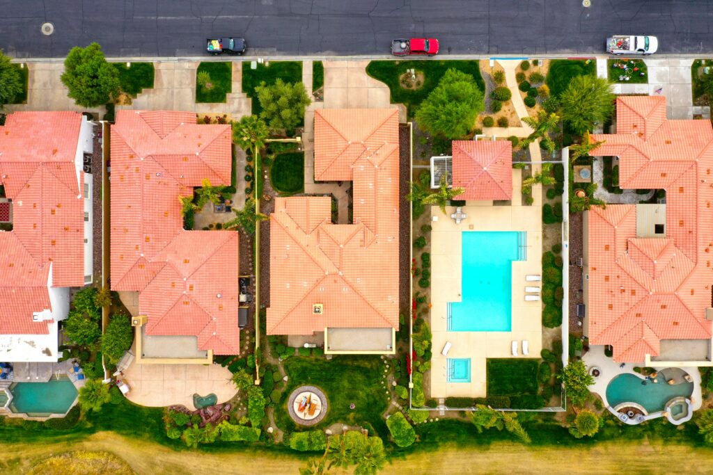 Aerial view showing suburban homes with pools in La Quinta, California, highlighting luxury lifestyle.